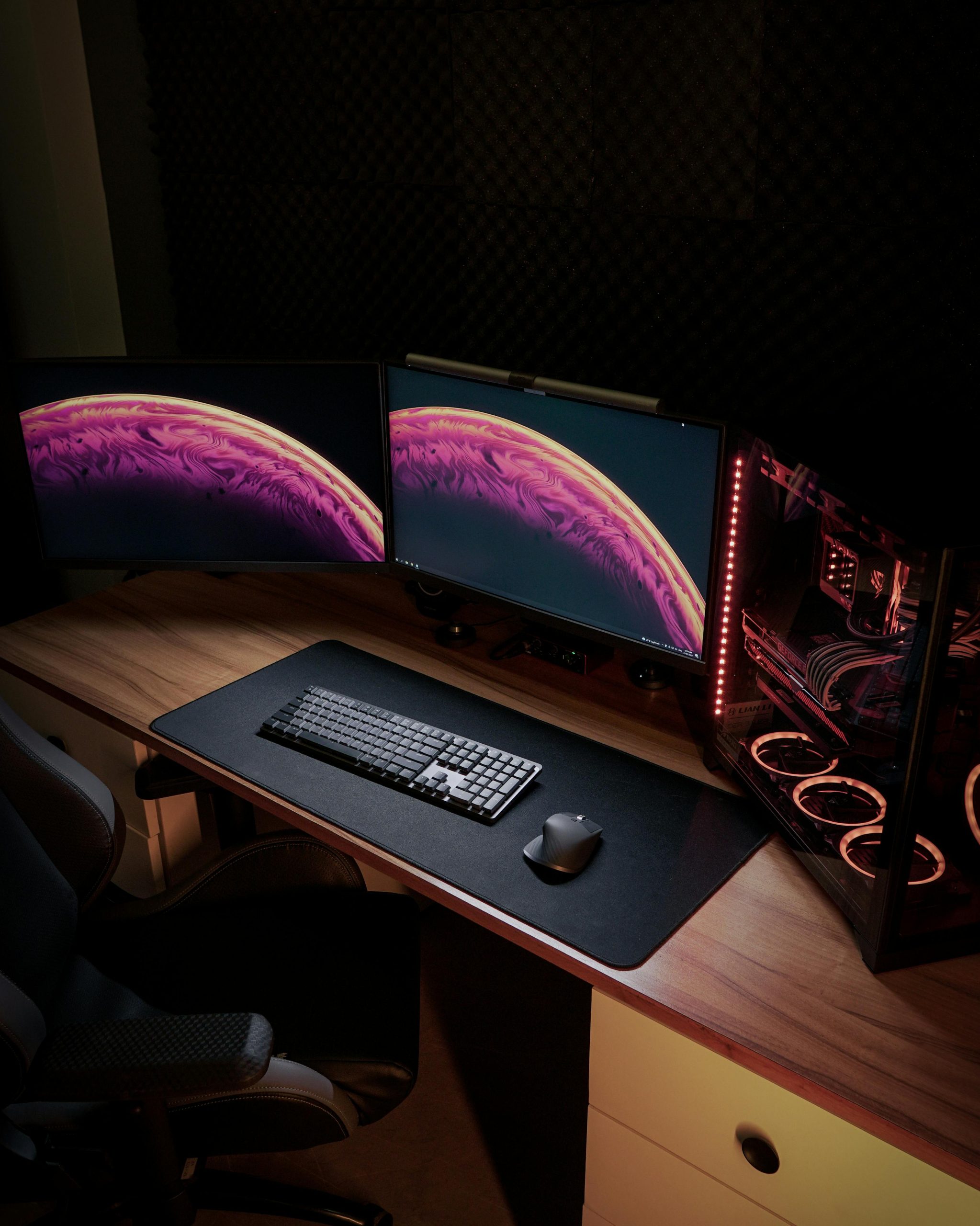 Sleek gaming setup with dual monitors and LED-lit PC for an immersive experience.